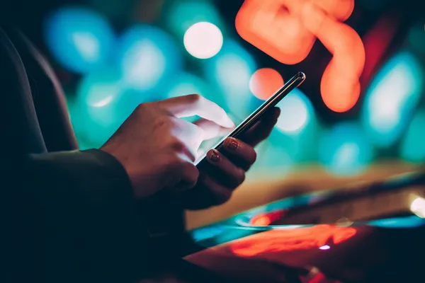 A glamorous woman holding casino chips in a neon-lit environment, representing the premium online casino atmosphere of JETA9.